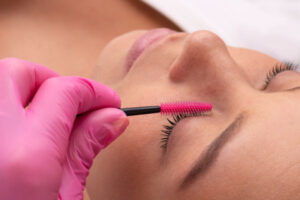 Una mujer recibiendo un tratamiento de pestañas en el salón de belleza Pelos&Nails, donde cuidamos cada detalle para realzar tu belleza.