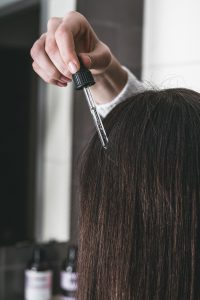 Mujer realizando tratamiento de su cabello con keratina, reflejando un momento de cuidado personal.